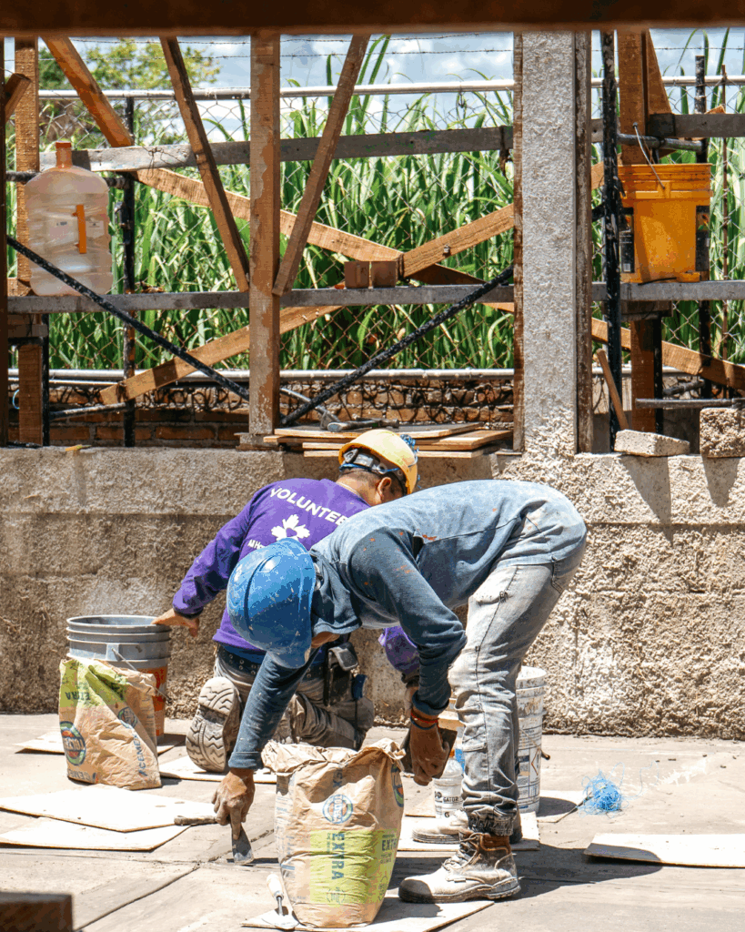 Volunteers finishing a cement floor