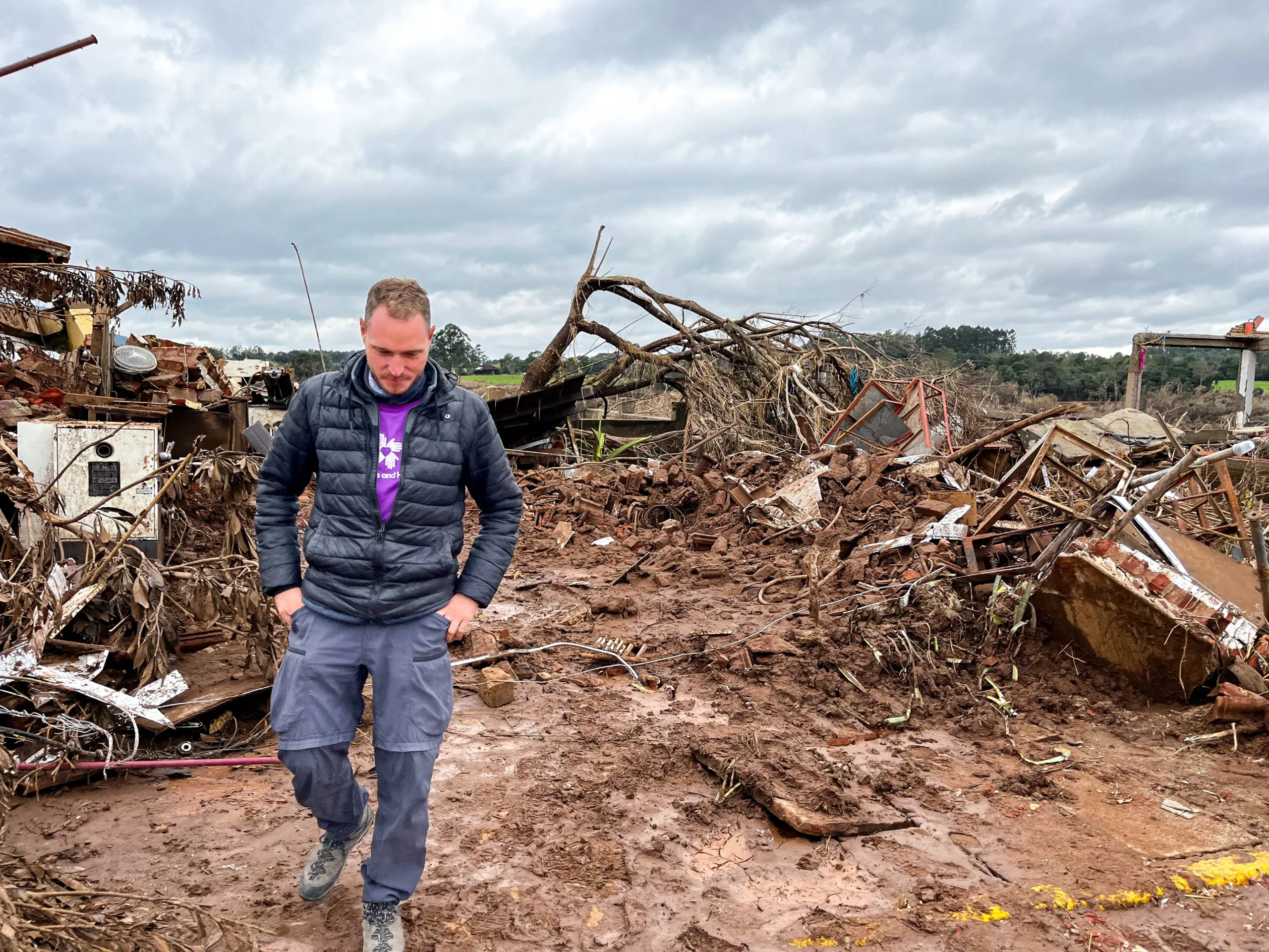 A volunteer walks through area damaged by floods