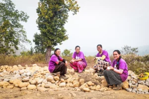 A group of four All Hands and Heart female masons in Nepal sit in a circle