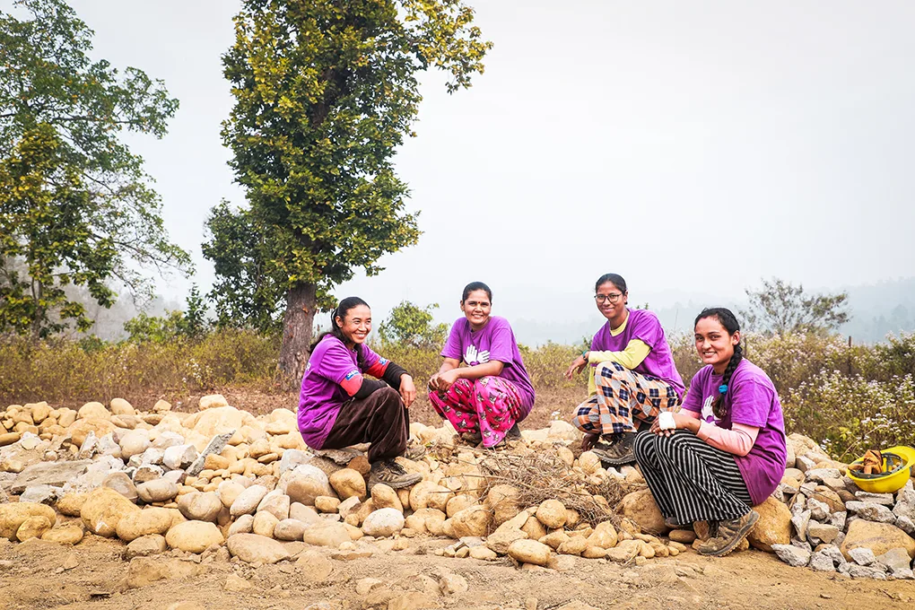 Un grupo de cuatro mujeres albañiles de All Hands and Heart, en Nepal, sentadas en círculo.