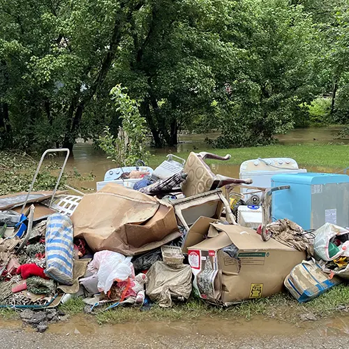odden household debris, furniture, and appliances piled on the roadside after severe flooding in Kentucky.