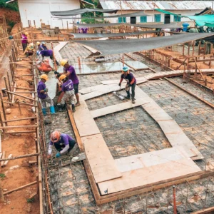 A group of All Hands and Hearts staff and volunteers working on the foundations of a new school rebuild