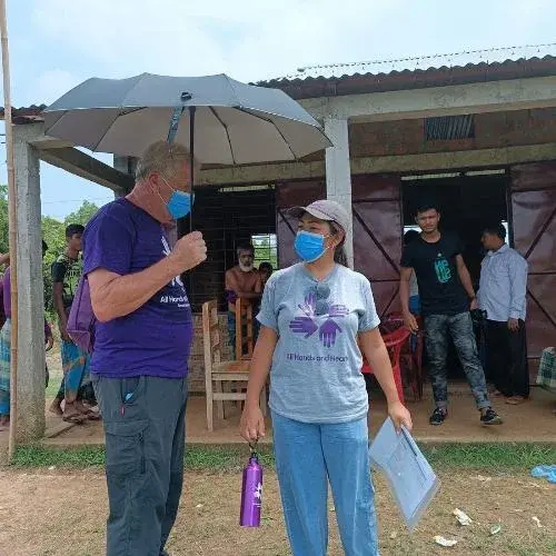 Two team members talking under an umbrella