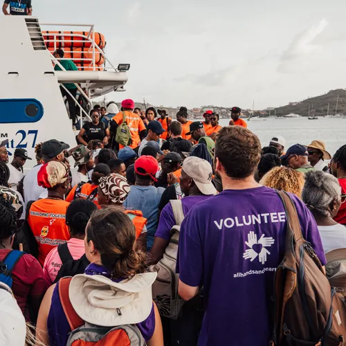 Hurricane Beryl relief volunteers and residents boarding a boat for evacuation and supply transport in Grenada.