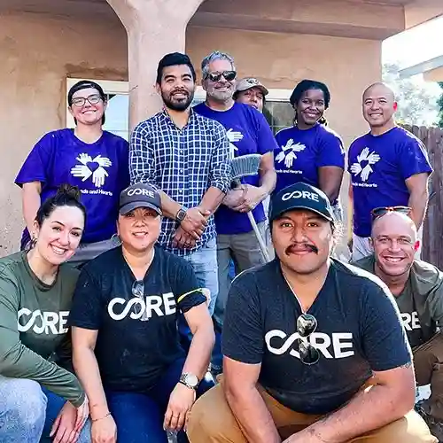 Group of All Hands and Hearts and CORE volunteers smiling together outside a California home after a day of flood recovery work.