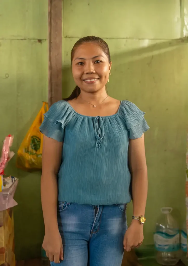Regine, Kindergarten teacher in Northern Tacloban, Philippines, smiles at the camera in her classroom