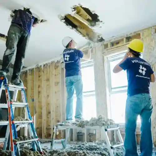 Florida Keys hurricane relief volunteers remove damaged ceiling and insulation from a storm-hit home.