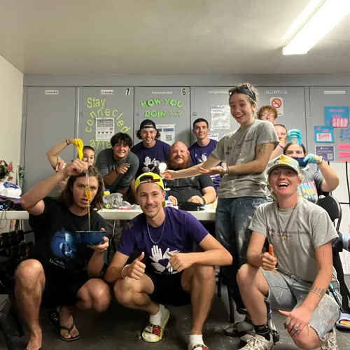 Florida Hurricane Ian volunteers take a break during disaster recovery work, smiling together inside a relief hub.