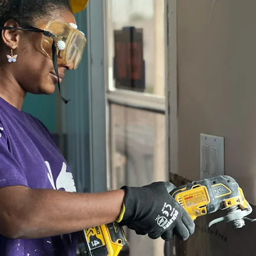 Volunteer helps with Florida Hurricane Ian recovery, using power tools to repair storm-damaged homes.