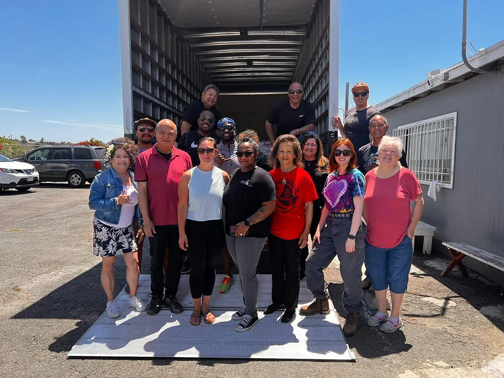 Community volunteers in Guam gather for a group photo in front of a supply truck during disaster relief efforts.