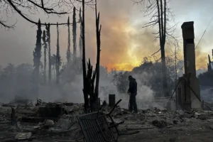 A figure walks through the charred remains of a neighborhood