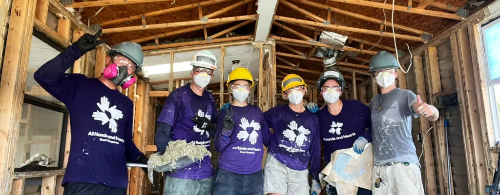 Disaster relief team works inside a gutted Florida home after Hurricane Ian, clearing debris and damaged materials.