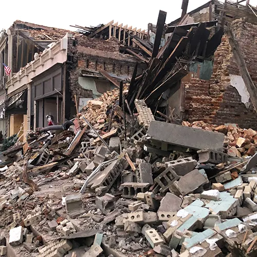 Severely damaged brick building in Kentucky reduced to piles of rubble following a tornado.