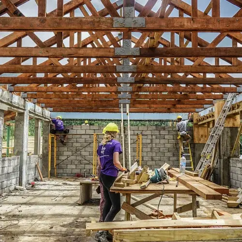 A volunteer stands in an unfinished building