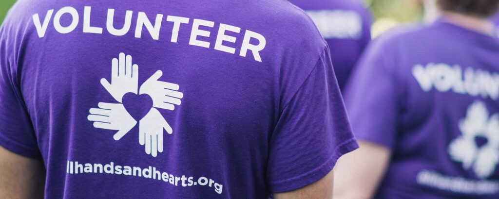 An international volunteer wearing the branded All Hands and Hearts - Smart Response volunteer shirt