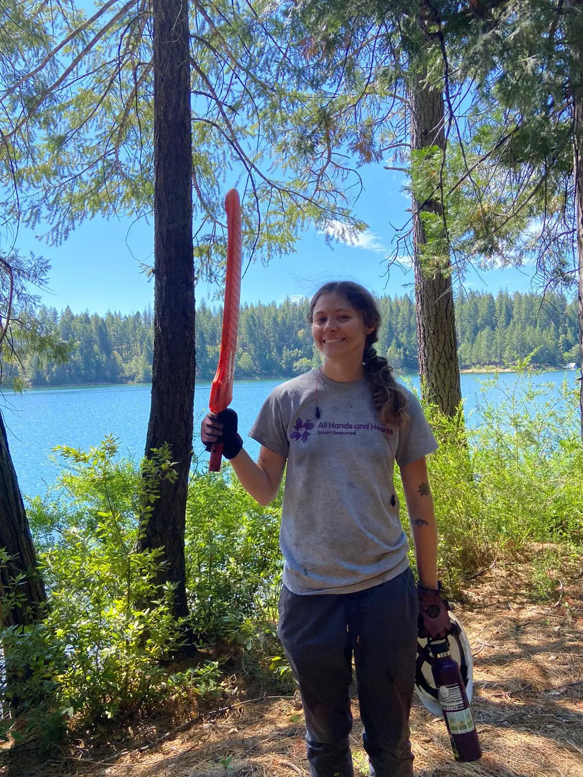 Liz, miembro del personal All Hands and Hearts , posa en un bosque quemado por un incendio forestal.