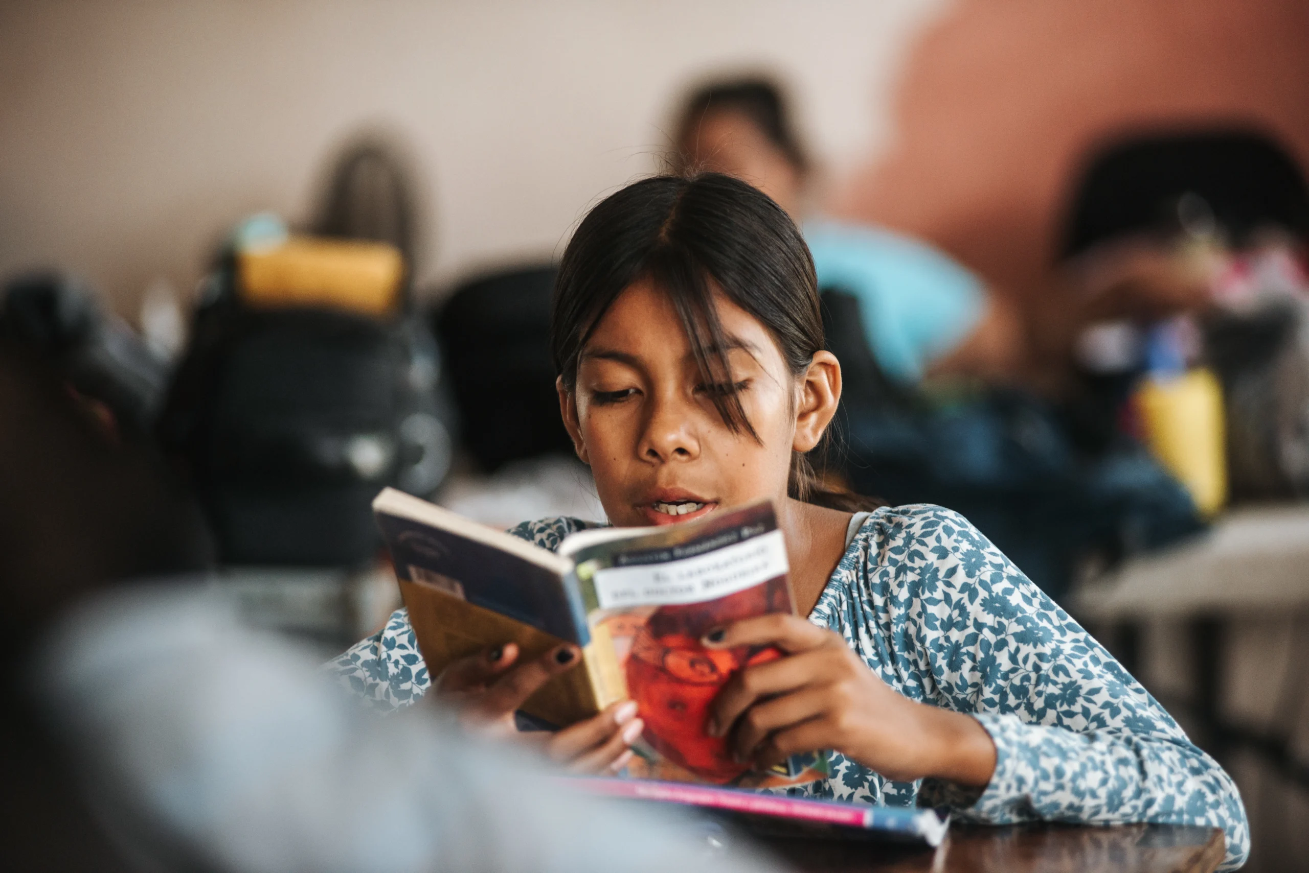 Female student reading book in classroom