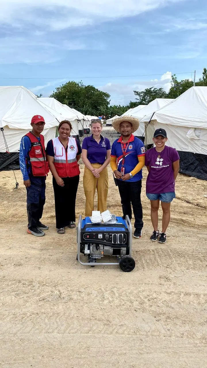 Five individuals stand in front of a generator