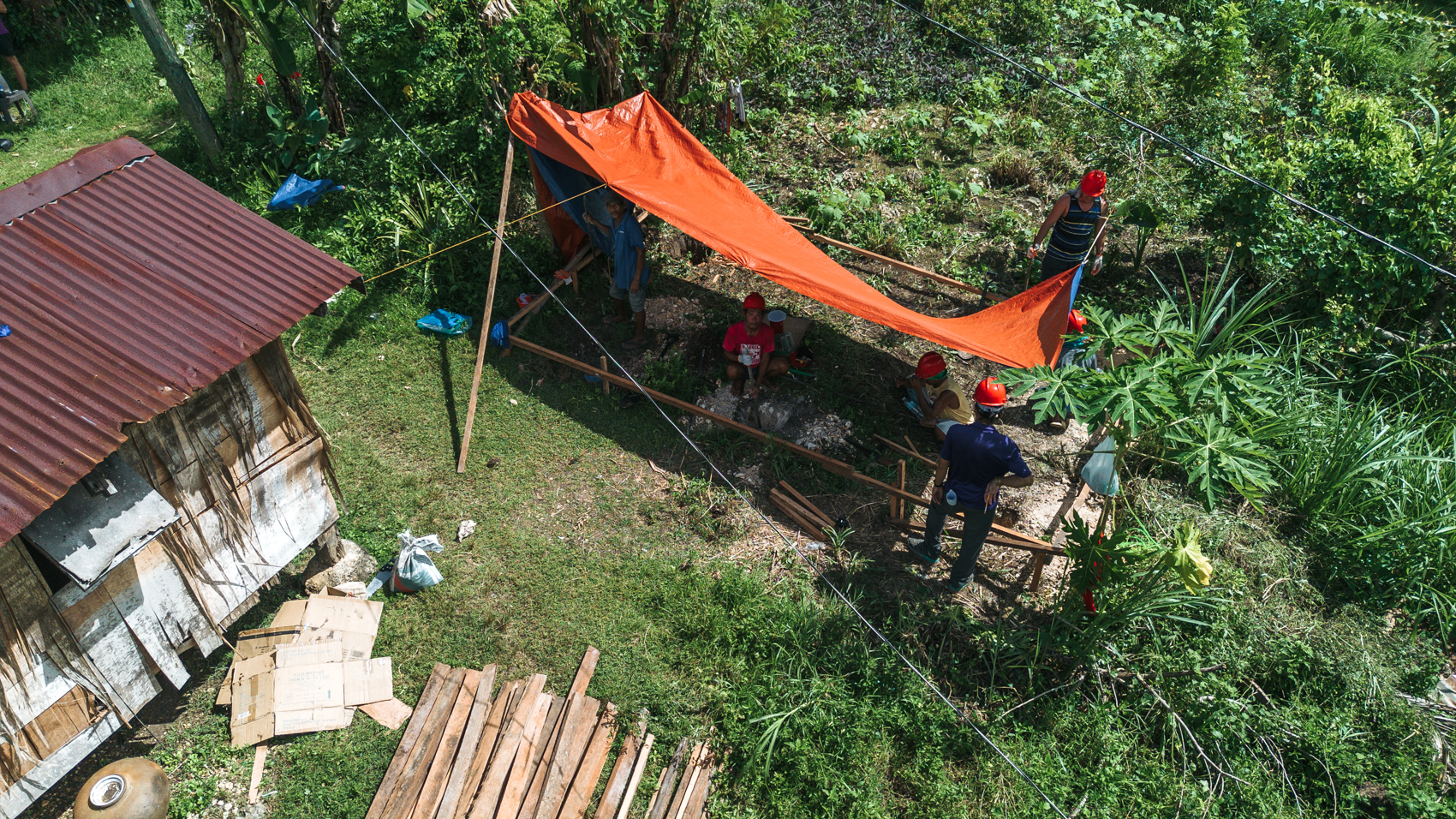 Un grupo de voluntarios All Hands and Hearts posa en un almacén de distribución sosteniendo kits de higiene