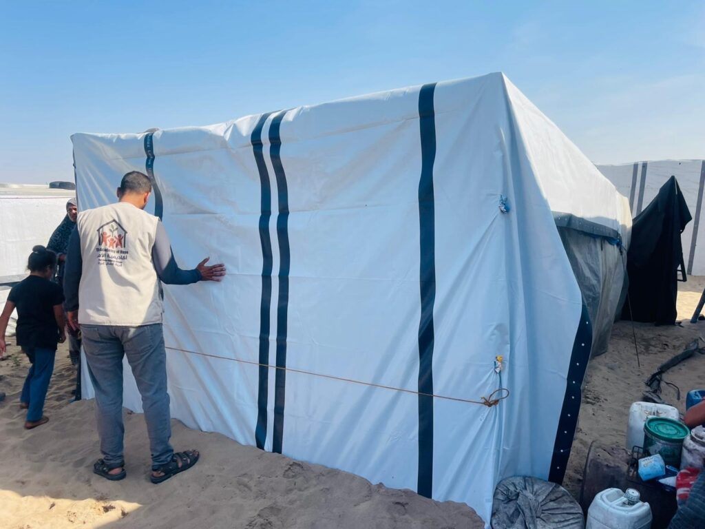 A tent shelter now covered in extra tarp protection.