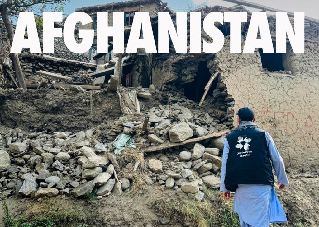 An All Hands & Hearts volunteers looks over a home destroyed by an earthquake