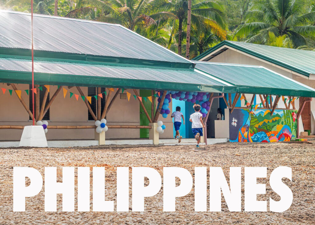 An image of 2 kids running out side of an All Hands & Hearts school